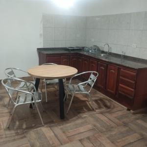 une cuisine avec une table, des chaises et un évier dans l'établissement Casa en alquiler por día en La Rioja, à La Rioja