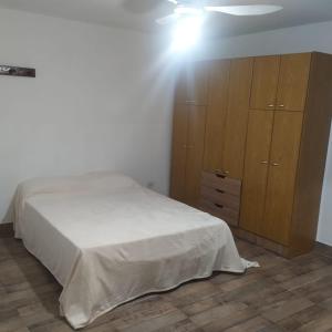 une chambre avec un lit et une armoire en bois dans l'établissement Casa en alquiler por día en La Rioja, à La Rioja