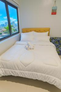 una cama en una habitación con ventana en The persimmon condominium studio, en Cebú 5 fotos más