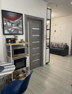 オデッサにあるArcadia Cozy Stayのテレビとテーブルと椅子のあるリビングルーム