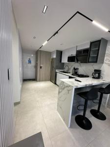 eine Küche mit einer Theke und ein paar Stühlen darin in der Unterkunft Apartmento Lecheria 3 hab 2 baños Moderno hasta 8 personas in El Morto de Barcelona