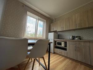 a kitchen with a table and chairs in a room at Apartamenty. Geroev Krut in Sumy +5 photos