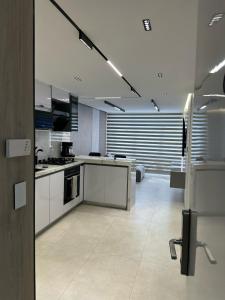 eine große Küche mit weißen Schränken und Geräten in der Unterkunft Apartmento Lecheria 3 hab 2 baños Moderno hasta 8 personas in El Morto de Barcelona