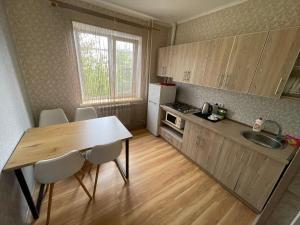 a kitchen with a table and chairs and a sink at Apartamenty. Geroev Krut in Sumy