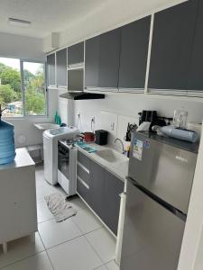 a kitchen with gray cabinets and a white floor at Apartamento Completo em Manaus in Manaus