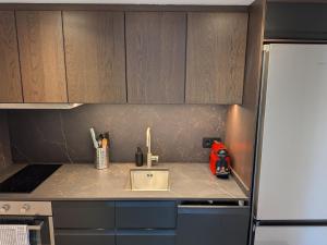 a kitchen counter with a sink and a refrigerator at Apartamento Gandiaport in Gandía