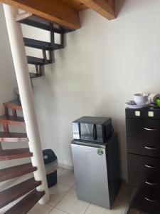 a kitchen with a microwave and a refrigerator next to a stairs at Bonito Mini Departamento 9 in Puebla