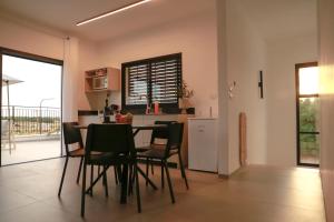 a kitchen and dining room with a table and chairs at Zomer חופשה בטבע in Beẕet