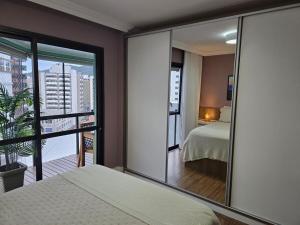 a bedroom with a bed and a view of a city at Apartamento de 2 quartos no Coração de Florianópolis in Florianópolis