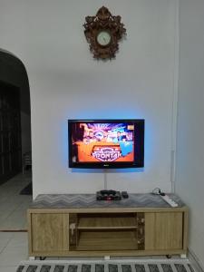 a flat screen tv sitting on top of a wooden entertainment center at Salza Homestay in Hulu Langat