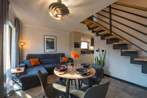 a living room with a blue couch and a table at Szatki Karkonoskie in Bukowiec