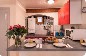 a kitchen with a counter with plates and a bowl of food at High Gardens Grand jardin en vieille ville in Annecy +6 photos