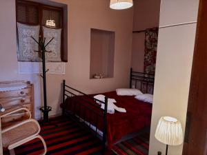 a bedroom with a red bed and a chair at Sophia's Stone House in Dimitsana