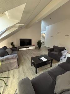 a living room with couches and a flat screen tv at Ferienwohnung am Flughafen in Braunschweig