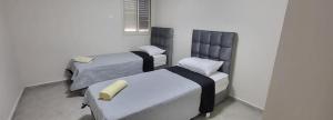 a room with two beds and a chair at דירת נופש לב ים in Tiberias