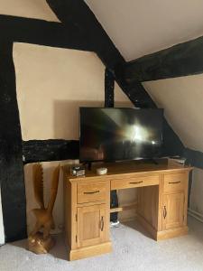 a television on a wooden stand in a room at Cefn Farm in Hyssington