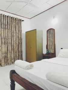 a bedroom with a bed and a mirror and curtains at Unawatuna House in Unawatuna +25 photos