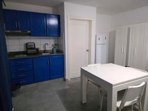 eine Küche mit blauen Schränken und einem weißen Tisch in der Unterkunft RELAX STUDIES DELUXE SOL CARIBE in Punta Cana