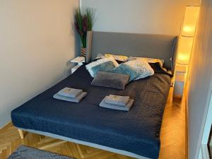 a bed with blue sheets and pillows on it at BaSoTo in Sopot