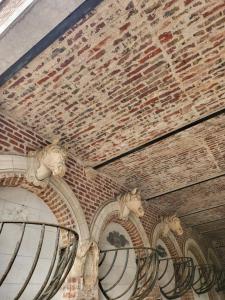 a brick wall with three horse heads on it at Hôtel De Ligny in Abbeville