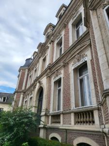 a large brick building with windows on the side at Hôtel De Ligny in Abbeville