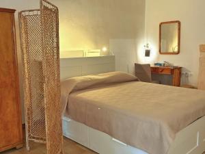 a bedroom with a bed and a desk and a mirror at Το σπίτι του Καντήλα in Leonidion