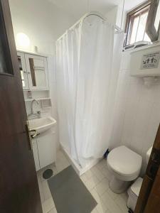 a white bathroom with a toilet and a sink at Το σπίτι του Καντήλα in Leonidion +31 photos