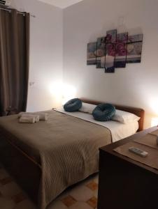 a bedroom with two beds with blue pillows on them at Lavinia House in Oliveri