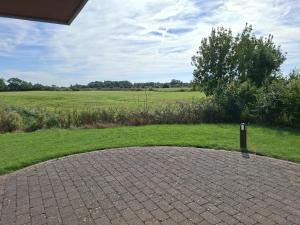 a brick driveway with a field in the background at Weitblick in Dorum-Neufeld
