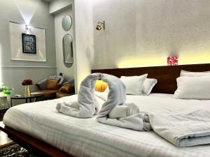 a bedroom with a bed with two folded towels on it at Project Artisan's Retreat! in Ghaziabad +10 photos