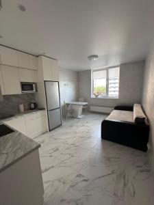a large room with a bed and a kitchen at Апартаменты Парковые озера in Kyiv