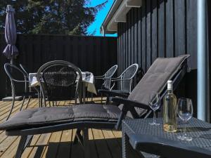 a patio with chairs and a table with a bottle of wine at 6 person holiday home in Hals-By Traum in Hals