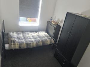 a small bedroom with a bed and a window at Near Manor Hospital Free Wifi in Walsall