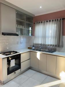 温特和克Little Haven Conerstone cottage的厨房配有白色橱柜和炉灶。