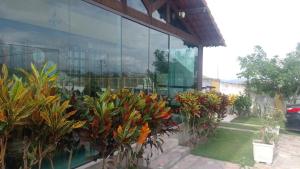 a building with a bunch of plants in front of it at Condomínio Alameda dos Pinheiros VI in Gravatá