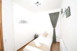 a white room with a bed and a window at JMG House - West Bromwich in West Bromwich