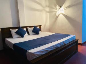 a bedroom with a bed with blue and white pillows at Ella Hidden Ferns in Ella