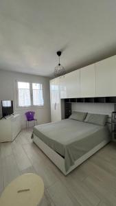 een slaapkamer met een groot bed en een paarse stoel bij La Casa di Nives in Scorzè