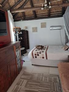 ein Schlafzimmer mit einem Bett und einer Kommode darin in der Unterkunft Pelican Place Guest Cottages in Durbanville + 63 Fotos