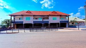 a building with a red roof on a street at Ramana Suites in Berekum