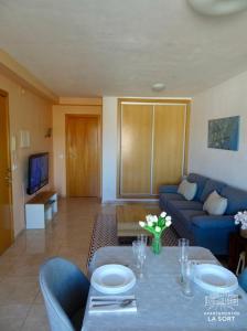a living room with a blue couch and a table at Ático La Sort con vistas al castillo in Valderrobres