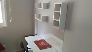 ein weißer Raum mit einem weißen Tisch und Regalen in der Unterkunft Cavalinho Branco in Águas de Lindóia