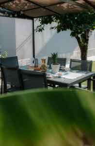 an outdoor table and chairs with a table and a tree at Casa Piero, relax e piscina privata tra le colline delle Langhe in Alba