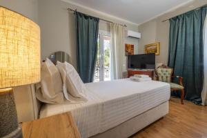 a bedroom with a large bed and a television at Olas y olivos in Akrotiri +37 photos