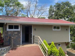 a small house with a red roof at Magnolia Farm Suites in San Isidro de El General +7 photos