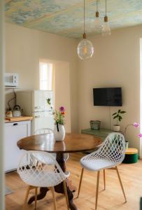 a kitchen with a wooden table and two chairs and a dining room at Cascina Piandamiane, soggiorno sostenibile e charme d'epoca nella natura delle Langhe in Rodello