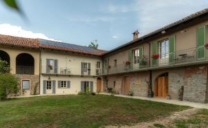 a row of houses with balconies and a yard at Cascina Piandamiane, soggiorno sostenibile e charme d'epoca nella natura delle Langhe in Rodello