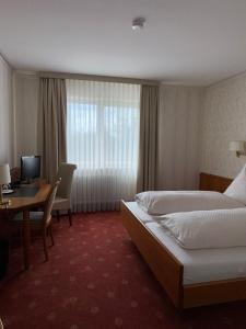 a hotel room with two beds and a desk at ChesaMia Hotel u Appartment in Römerberg