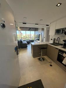 eine Küche und ein Wohnzimmer mit einer Couch und einem Tisch in der Unterkunft Apartamento Lecheria 2 Hab 2 Baños Terraza Planta Eléctrica - De Lujo in El Morto de Barcelona