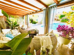 São MiguelにあるSunrise Villa Alvoradaの籐の椅子と植物のあるテーブル付きのパティオ